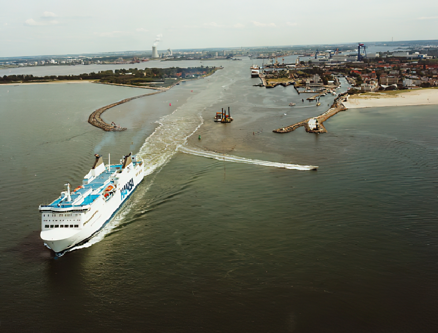 Historisches Archivfoto: Eine Fähre verlässt die Moleneinfahrt in Warnemünde, im Hintergrund der Überseehafen Rostock und rechts der Strand von Warnemünde