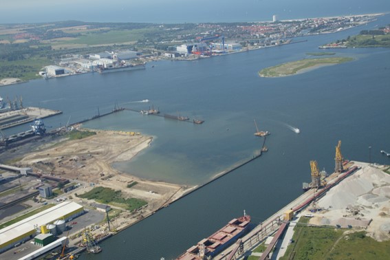 Luftbild der Hafenerweiterung auf Pier 3 mit Absteckungen im Wasser für geplante Aufschüttungen, mit Blickrichtung Warnemünde