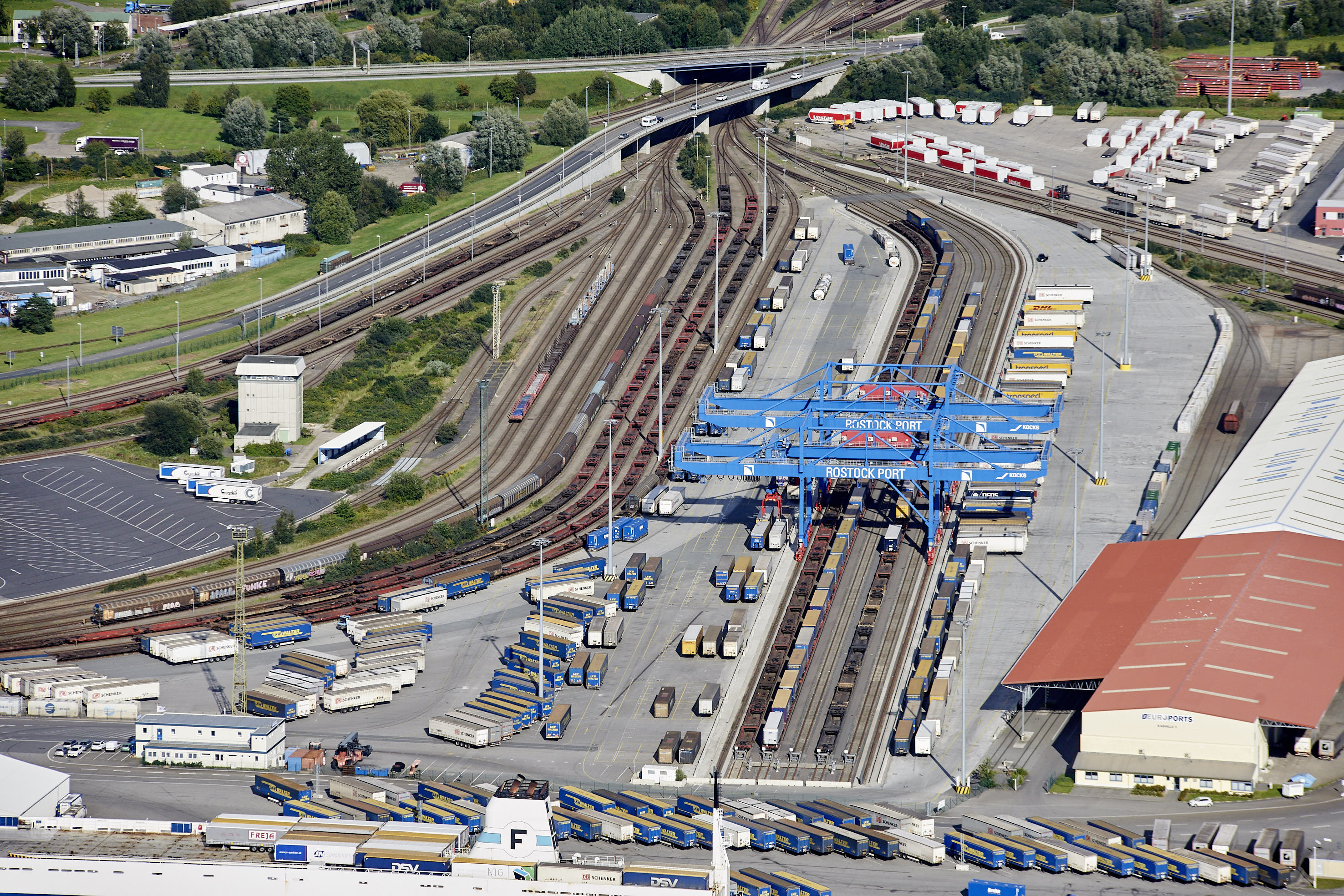 Luftaufnahme des Terminals für kombinierten Ladungsverkehr in Rostock. Auf dem Terminal stehen zahlreiche Trailer.