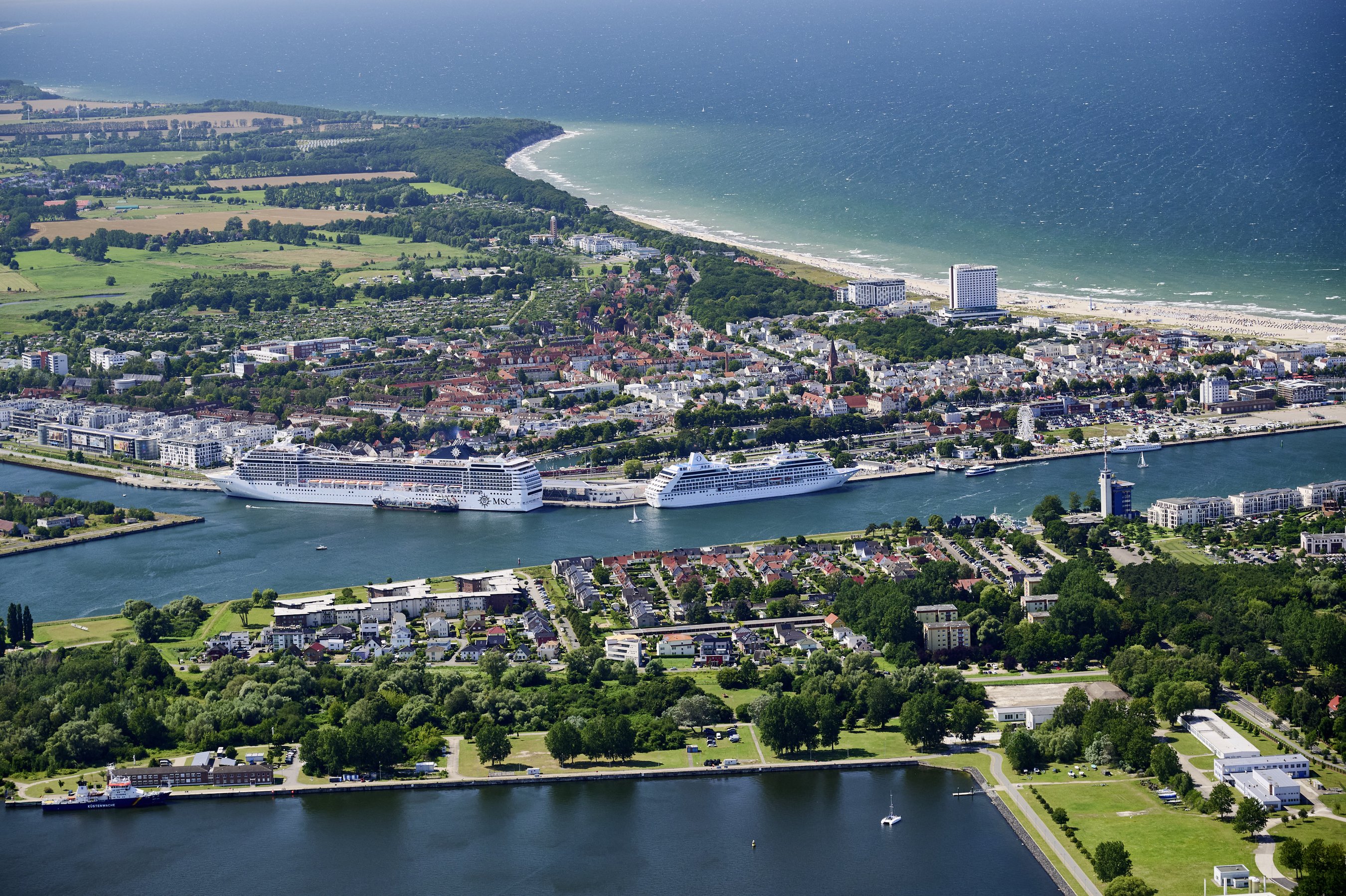 Luftbild des Kreuzfahrthafens Warnemünde Zwei Kreuzfahrtschiffe liegen an der Warnemünder Pier, eines davon wird gerade von einer Bunkerbarge betankt.