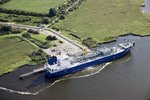 Luftaufnahme des Chemiehafens Rostock. Ein Schiff liegt am Liegeplatz und wird be- und entladen.