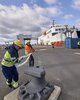Drei Festmacher machen ein Fährschiff fest